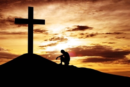 15193306 - a man making a confession to the cross, shot under dawn sky